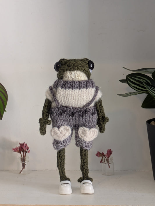 Grenouille d'art Gustave de face, portant une salopette grise avec des cœurs